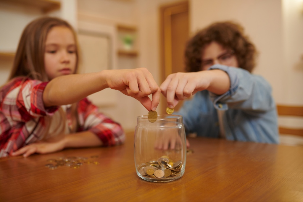 savings-boy-girl-siiting-table-putting-savings-jar.jpg дети